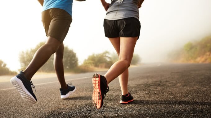 A person tying their running shoes, ready to exercise, with a doctor's stethoscope subtly in the background.
