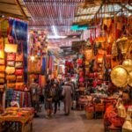 Divers articles d'artisanat marocain traditionnel, incluant poteries, tapis et vêtements, symbolisant la richesse culturelle et le dynamisme des exportations.