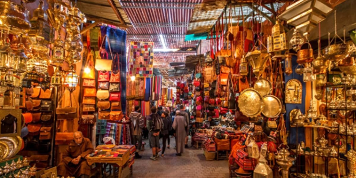 Divers articles d'artisanat marocain traditionnel, incluant poteries, tapis et vêtements, symbolisant la richesse culturelle et le dynamisme des exportations.
