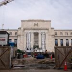 Federal Reserve building with a graph showing declining interest rates, symbolizing Mark Zandi's forecast.