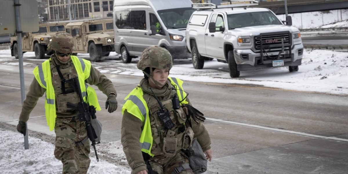 National Guard troops deployed in a U.S. city street, representing federal intervention and associated costs.