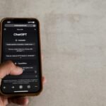 A person interacting with a holographic display showing AI concepts and data, symbolizing online learning and technological advancement.