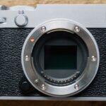 Fujifilm X-E5 mirrorless camera with a compact prime lens, showcasing its retro rangefinder design.