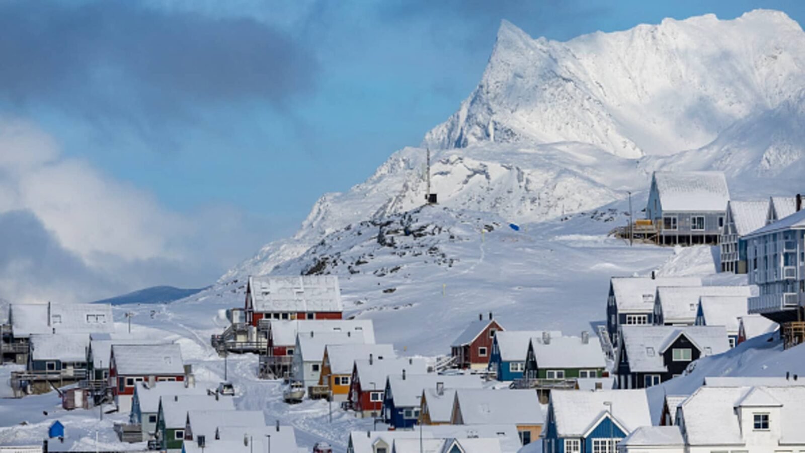 Icebergs floating in a bay with mountains in the background, symbolizing Greenland's strategic Arctic landscape.