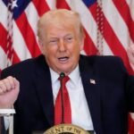 President Donald Trump speaking, with a map of Greenland in the background, symbolizing his controversial proposal.