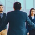 Two business professionals exchanging a document, symbolizing a clear and effective handoff in a professional setting.