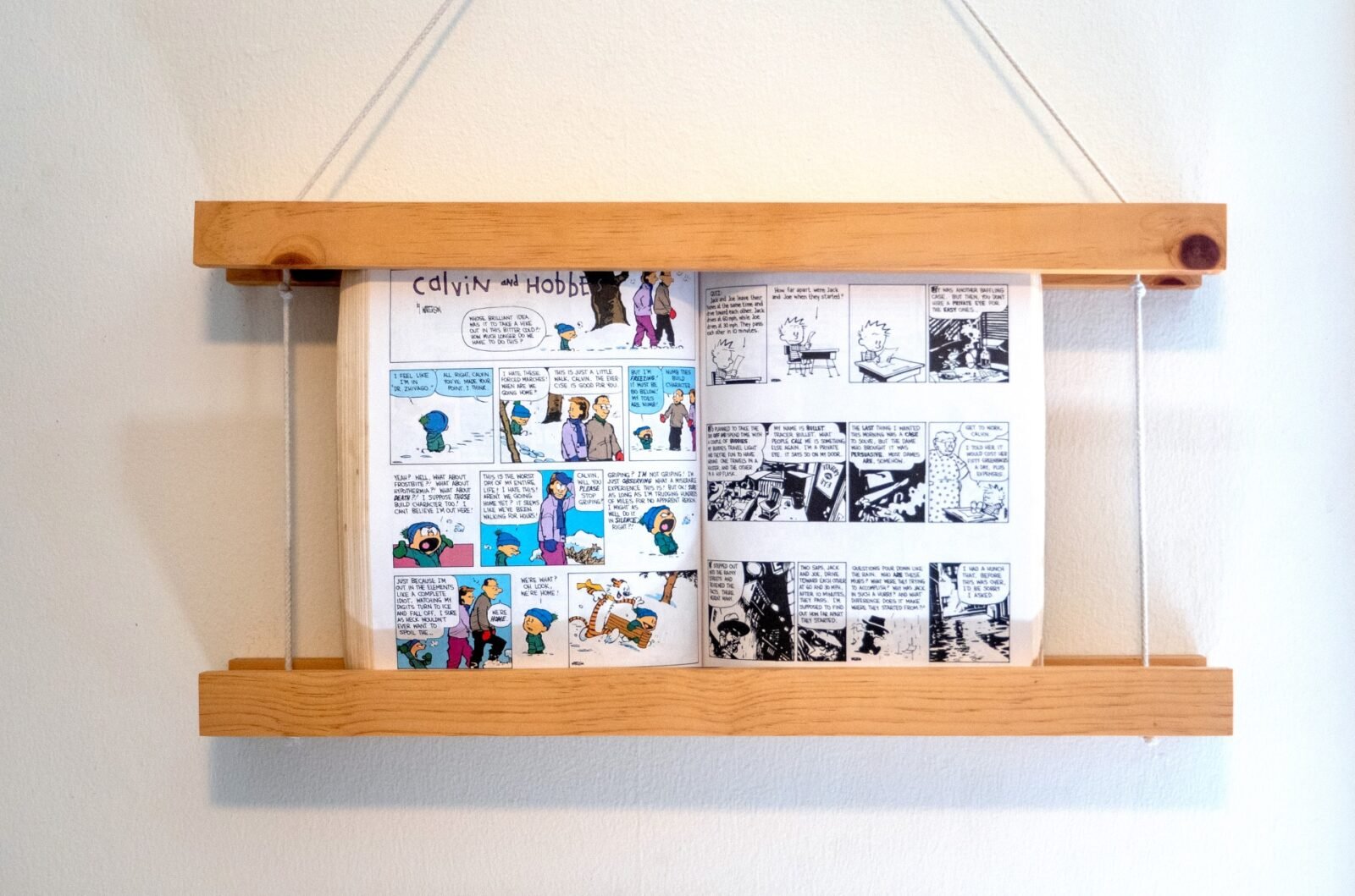 A beautifully crafted wooden hanging frame displaying an open book on a wall.