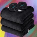 Three different heated blankets, one flannel, one throw, and one textured, draped over furniture in a cozy home setting.