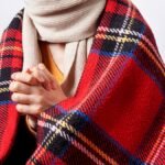 A cozy, warm room during a power outage, with blankets, candles, and a family gathered together.