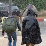 Vue aérienne de Ksar El Kébir inondée avec des bâtiments partiellement submergés et des équipes de secours intervenant.