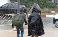 Vue aérienne de Ksar El Kébir inondée avec des bâtiments partiellement submergés et des équipes de secours intervenant.