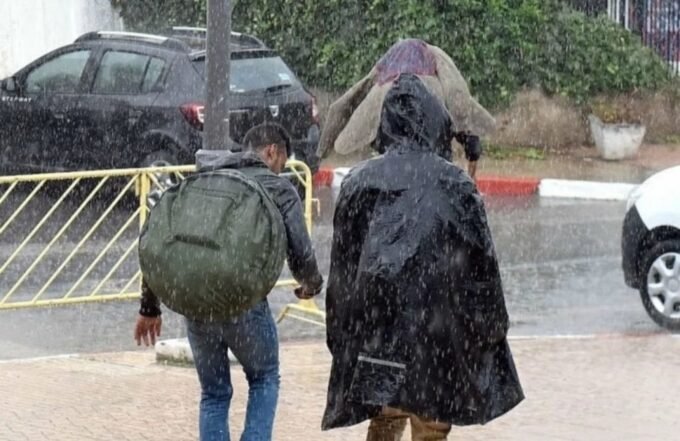 Vue aérienne de Ksar El Kébir inondée avec des bâtiments partiellement submergés et des équipes de secours intervenant.