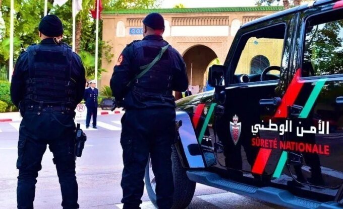 Moroccan police apprehending a suspect, with Interpol logo in the background, symbolizing international cooperation against drug trafficking.