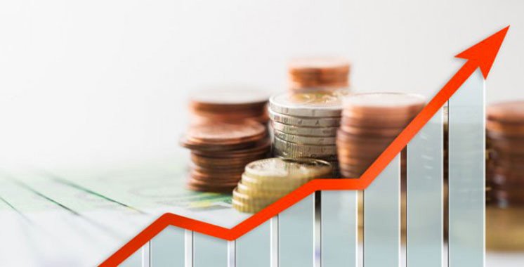 Vue aérienne d'un paysage urbain marocain moderne avec des infrastructures de transport et des bâtiments symbolisant le développement économique.