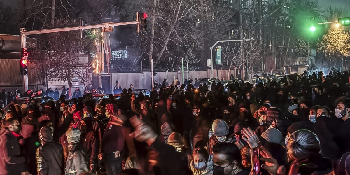 Iran's Deepening Crisis: Regime Issues Warnings Amid Escalating Protests and Fatalities 3 Protesters in Iran waving phone flashlights in the dark during a demonstration