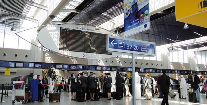 Un avion décollant d'un aéroport moderne au coucher du soleil, symbolisant l'essor du transport aérien au Maroc.