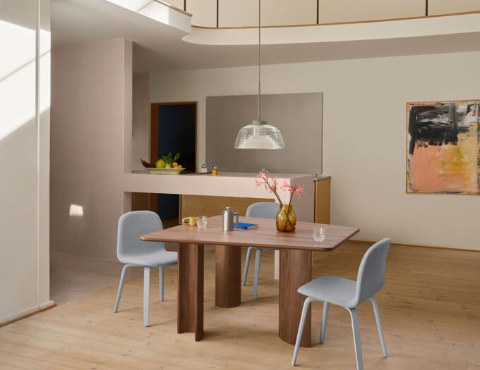 The Re-norm Table by Maria Bruun for Muuto, showcasing its unique asymmetrical form, convex legs, and form-pressed birch plywood construction in a modern interior.