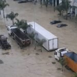 Vue aérienne des inondations à Ksar El Kébir, avec des véhicules des Forces Armées Royales (FAR) en action pour le sauvetage et l'assistance des populations sinistrées.