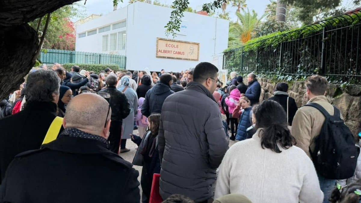 Des parents d'élèves manifestent devant une école française au Maroc, brandissant des pancartes pour protester contre l'augmentation des frais de scolarité.