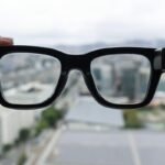 A person wearing Meta Ray-Ban Display glasses, demonstrating the new handwriting feature for discreet messaging.