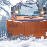 Paysage hivernal au Maroc avec des montagnes enneigées et un ciel nuageux, illustrant les conditions météorologiques extrêmes annoncées.