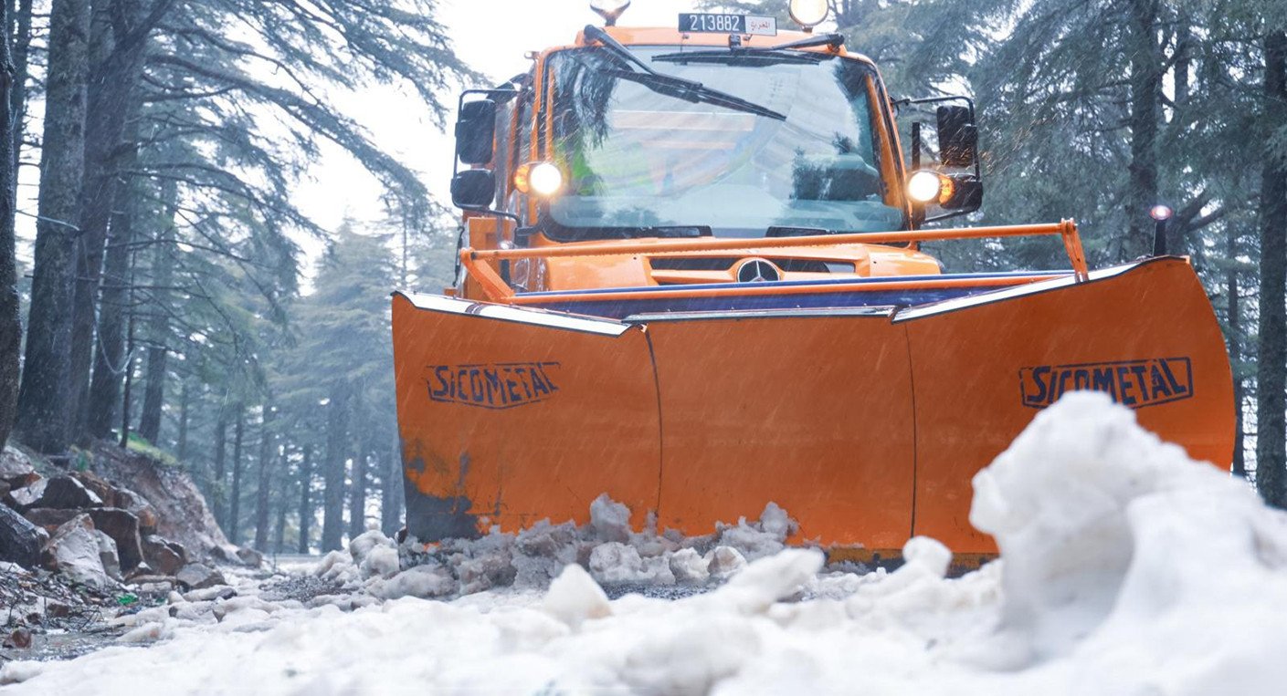 Paysage hivernal au Maroc avec des montagnes enneigées et un ciel nuageux, illustrant les conditions météorologiques extrêmes annoncées.