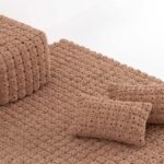 A collection of MOMOS pillows, poufs, and rugs in Anthracite and Camel colors, showcasing their unique textured pattern.