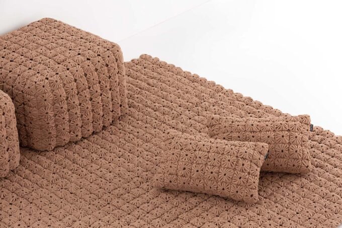 A collection of MOMOS pillows, poufs, and rugs in Anthracite and Camel colors, showcasing their unique textured pattern.