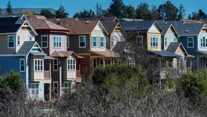 A graphic showing a downward trend in mortgage rates with a house icon in the background