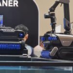 Le robot de piscine Mova Rover Master avec son bras articulé, flottant dans une piscine éclairée.