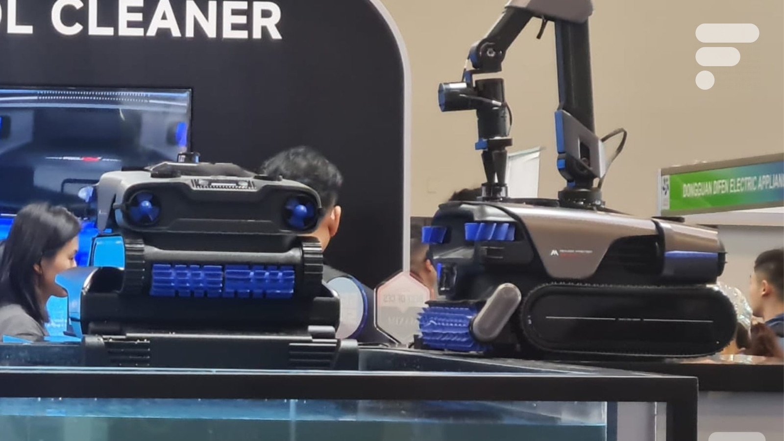 Le robot de piscine Mova Rover Master avec son bras articulé, flottant dans une piscine éclairée.