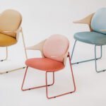 The Mysa Chair by Studio Kohlhass, a modern armchair with a bent plywood backrest embracing the seat, shown in a contemporary interior setting.