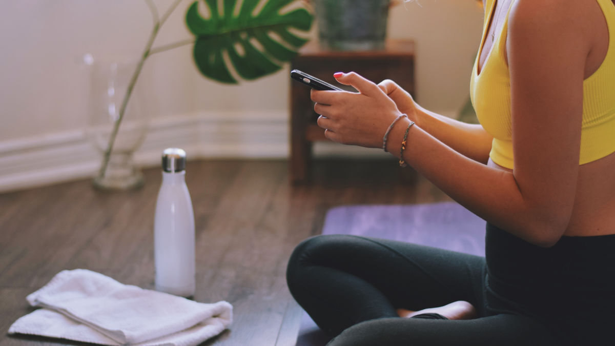 Smartphone screen displaying various New Year's resolution tracking apps like Strong, Peloton, and Lifesum, symbolizing goal achievement.