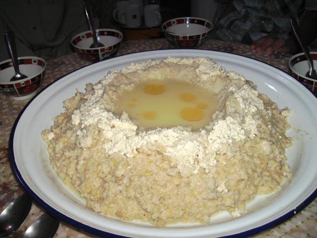 Famille amazighe célébrant Yennayer avec des sfenj et toghrifin, symboles du Nouvel An agraire.