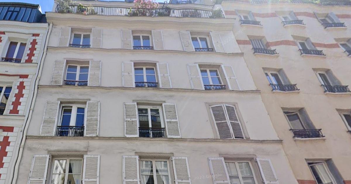 Scène de l'effondrement d'un appartement rue Amelot à Paris, avec des débris et des véhicules de secours.
