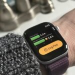 A smartphone and Apple Watch displaying the P Water app interface, with a glass of water in the background.