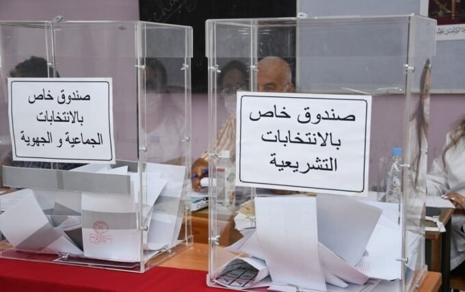 Illustration de la torpeur politique au Maroc, avec des symboles de partis et de la société civile en sommeil devant le Parlement.