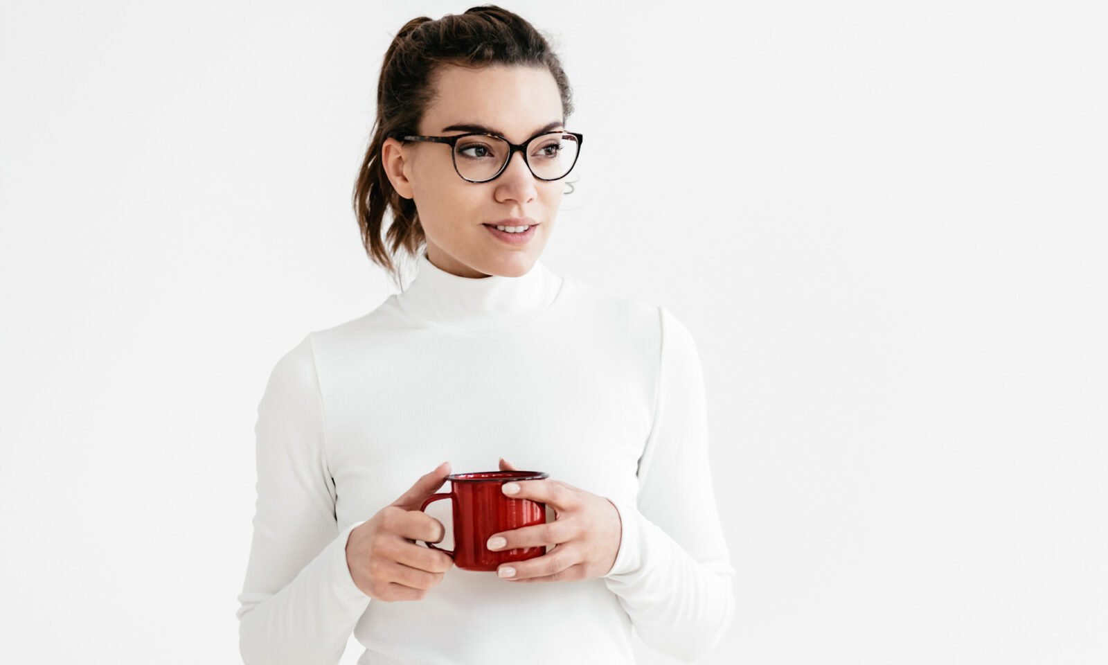 A warm, golden digestive elixir in a clear glass, garnished with a lemon slice and a cinnamon stick, on a wooden surface.