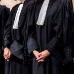 Une balance de justice symbolisant le droit et les avocats, avec des documents juridiques en arrière-plan.
