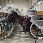 Un homme posant fièrement avec un vélo électrique de marque Solex, symbolisant le renouveau et la modernité de la marque française.