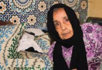 Portrait de Safia Ziani, actrice marocaine légendaire, souriante et élégante, en hommage à sa carrière.