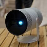 The Samsung Freestyle+ portable projector displaying a vibrant, perfectly calibrated image on an uneven wall surface.