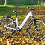 Le vélo électrique Scott Axis 20 Wave en couleur bleu clair, posé sur un chemin, mettant en valeur son design robuste et ses roues de 29 pouces.