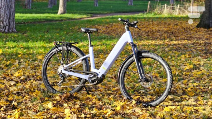 Le vélo électrique Scott Axis 20 Wave en couleur bleu clair, posé sur un chemin, mettant en valeur son design robuste et ses roues de 29 pouces.