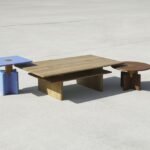 A collection of SNAPP Solis tables, showcasing geometric forms in warm wood tones.