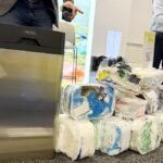 The Clear Drop Soft Plastic Compactor next to a pile of compacted plastic bricks it produces.