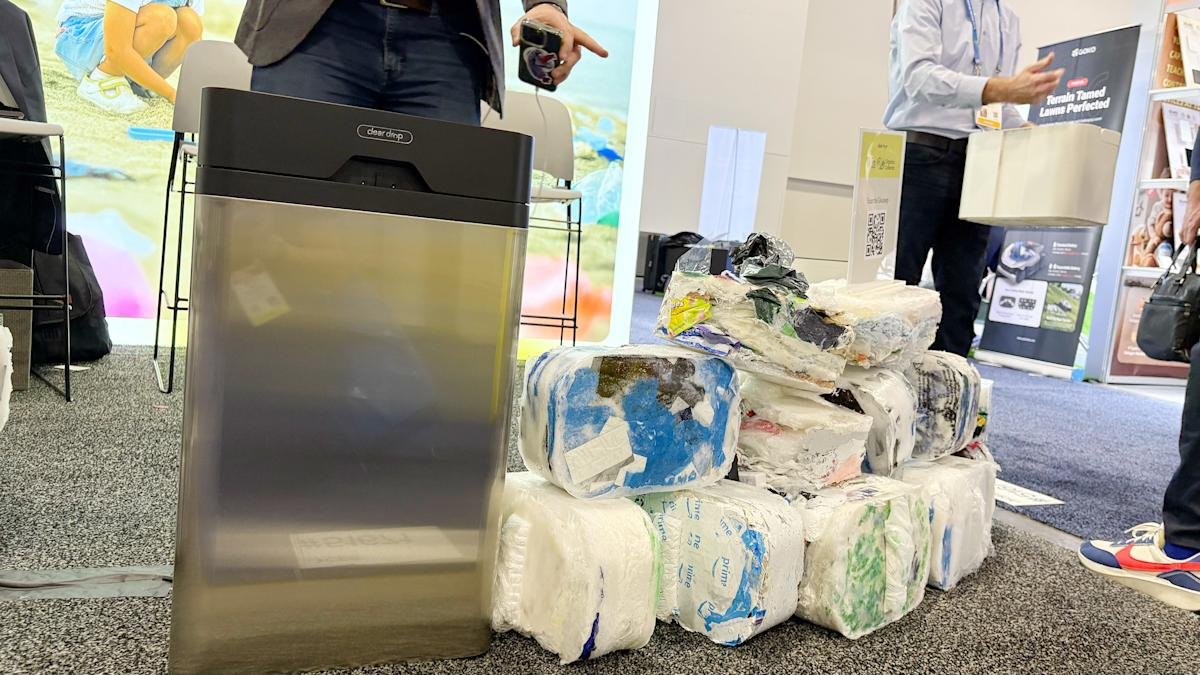 The Clear Drop Soft Plastic Compactor next to a pile of compacted plastic bricks it produces.
