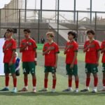 Jeunes footballeurs marocains U15 célébrant leur victoire au tournoi UNAF, brandissant un trophée.