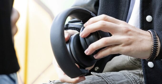 TDM Neo headphones rolled up into a compact Bluetooth speaker, showcasing their unique transforming design.