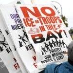 Tech workers protesting or holding signs against ICE actions, with a backdrop of a tech company building.